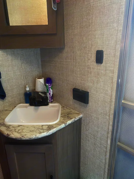 RV rental bathroom features: compact sink, gray vanity, marble-pattern counter, wall outlet & switch.. Gulf Stream Other 2021