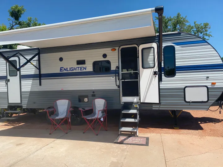 This RV rental features an extended awning, two camping chairs, and open door with steps. Ready for your next adventure.. Gulf Stream Other 2021