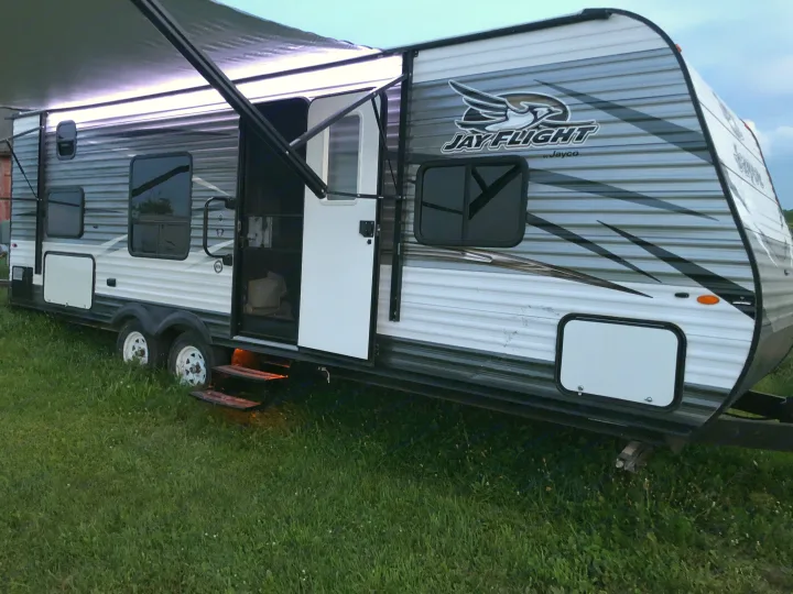 Spacious Jayco Jay Flight travel trailer, awning lit, ready for your next. Jayco Jay Flight 2018