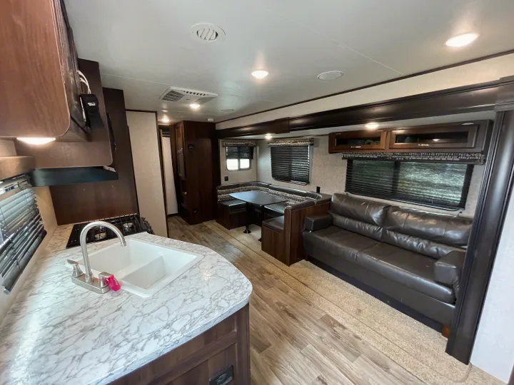Spacious RV rental interior with kitchen, U-shaped dinette, and comfortable sofa. Perfect for road trips & family adventures.. Jayco Flight SLX 2018