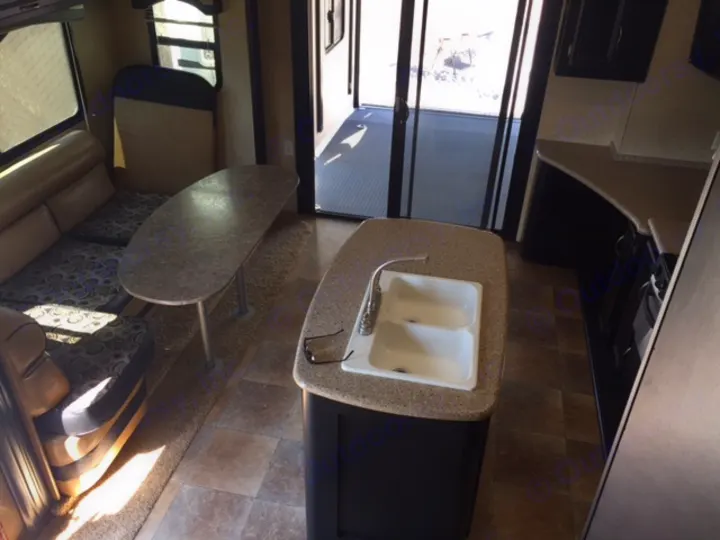 This RV rental offers a spacious toy hauler interior with kitchen island, dinette, and rear ramp access.. Heartland Torque 2015