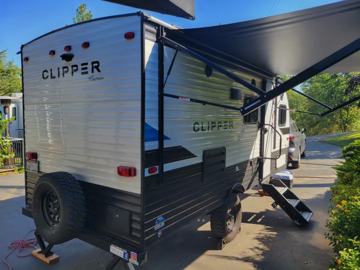 A Coachmen Clipper travel trailer, perfect for your next RV rental adventure, parked with its awning extended.. Coachmen Clipper 2021