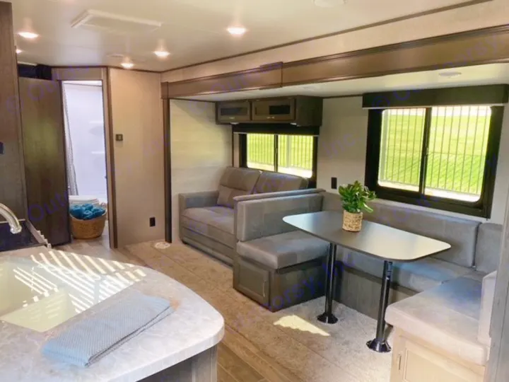 Spacious RV rental interior featuring a kitchen, dinette with table, living area sofa, and bathroom. Enjoy comfort on the road.. Jayco Jay Flight SLX 2021