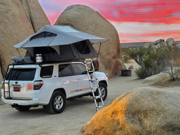 Overlanding 4Runner with rooftop tent set up in desert at pink sunset, offering a unique RV rental camping experience.. Toyota 4Runner 2021