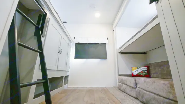 RV rental bunkhouse: Left shows a ladder to a bunk & cabinets. Right has bunk beds & seating. Center features a window.. Forest River Vibe 2021