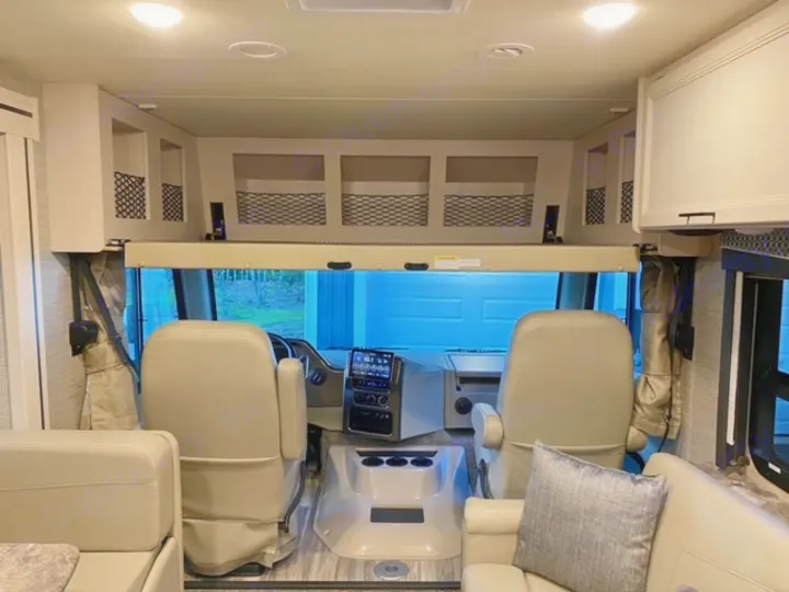RV rental interior: A spacious motorhome with comfortable cockpit seats, overhead bunk, and inviting living area.. Thor Motor Coach A.C.E 2021