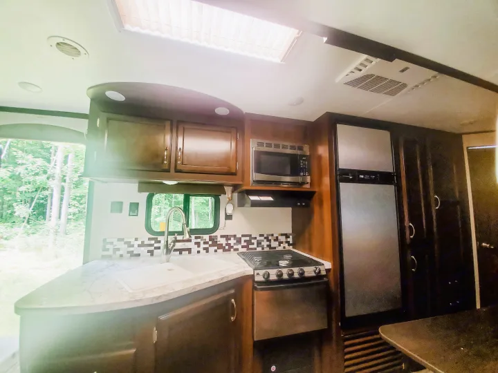 RV rental kitchen: modern appliances, sink, stove, microwave, and fridge visible in bright interior.. Jayco Jay Flight 2018