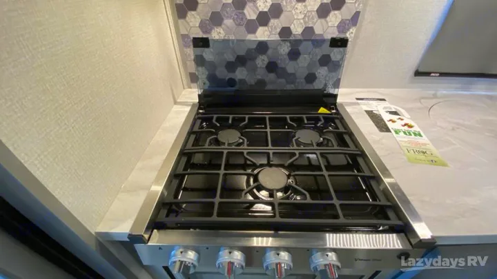 Explore cooking in your rv rental! This RV kitchen features a 3-burner gas stove, glass cover, and tiled backsplash.. Forest River Solera 2021