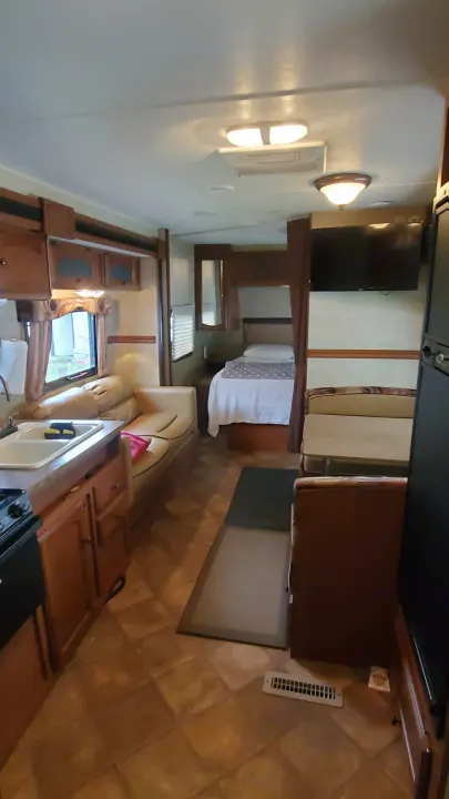 This rv rental interior features a functional kitchen, comfortable couch, dinette, and bedroom. Perfect for your next adventure.. Dutchmen Dutchmen 2012
