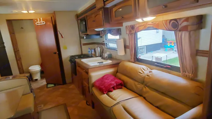Spacious RV rental interior featuring a full kitchen, comfy living area, and visible bathroom, ideal for family trips.. Dutchmen Dutchmen 2012