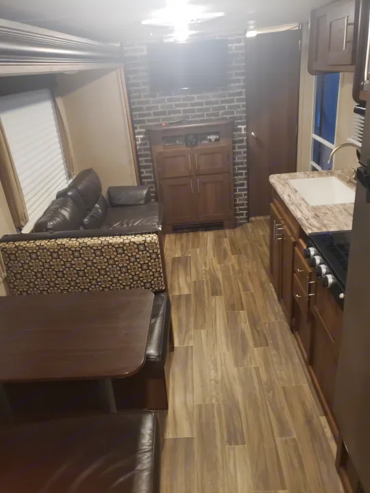 Comfortable RV rental interior featuring kitchen, dining, and living area with a convertible sofa bed.. Shasta Oasis 2019