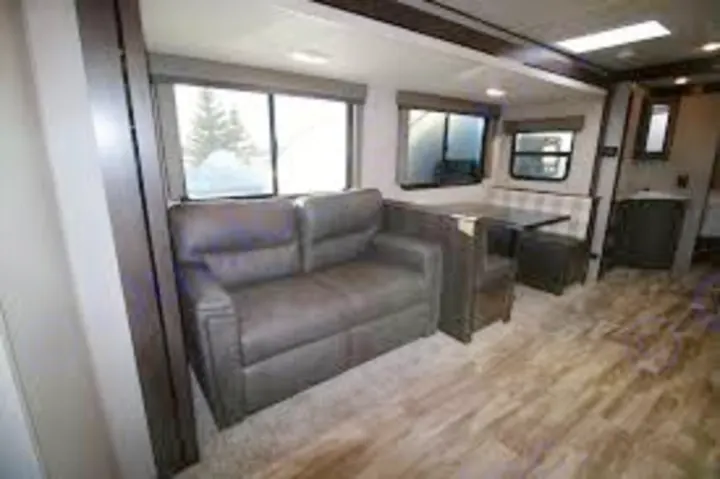 RV rental living area, featuring a cozy sofa & dining booth. Ideal for your next road trip or family camping.. Grand Design Other 2021