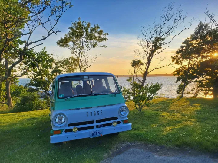 Two-tone vintage Dodge van by the ocean at sunset. Imagine this classic RV rental adventure!. Dodge A108 1969