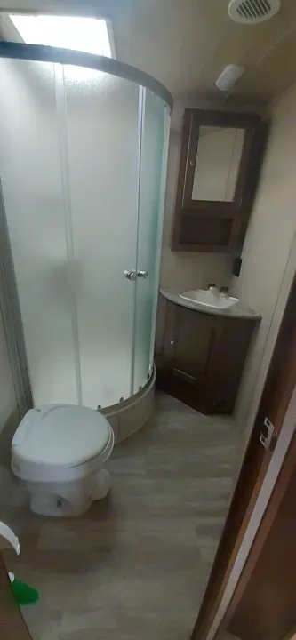 Explore this compact rv rental bathroom, complete with a shower, toilet, sink, and mirrored cabinet.. geo 267RL 2018