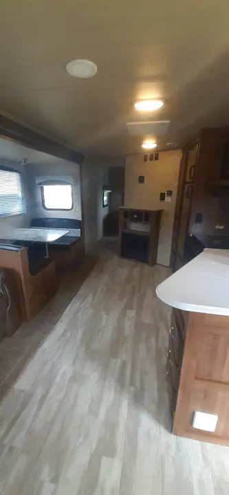 RV rental's inviting interior: modern kitchen, dinette, and living space with sleek flooring and ample lighting.. geo 267RL 2018