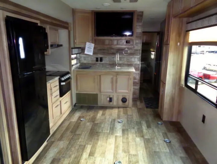 This RV rental interior boasts a well-equipped kitchen, wood-plank flooring, and versatile tie-down points for gear.. Coachmen Catalina 2021