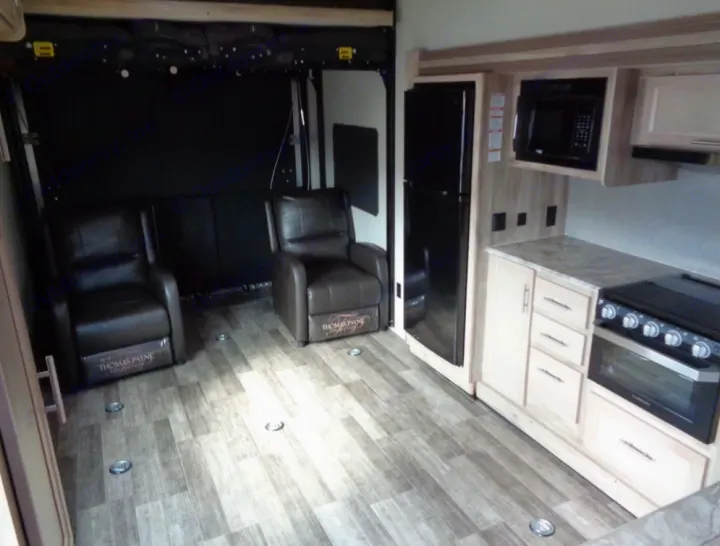 Spacious RV rental interior featuring a full kitchen, two recliners in the living/garage space, and durable flooring.. Coachmen Catalina 2021