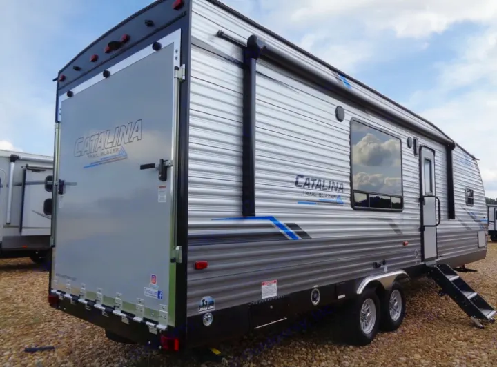 Toy hauler RV rental: a gray Catalina Trail Blazer travel trailer with a large rear ramp door and side awning.. Coachmen Catalina 2021