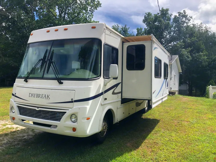 White Daybreak RV rental with an extended slide-out, parked on a grassy lawn.. Damon Daybreak 2005
