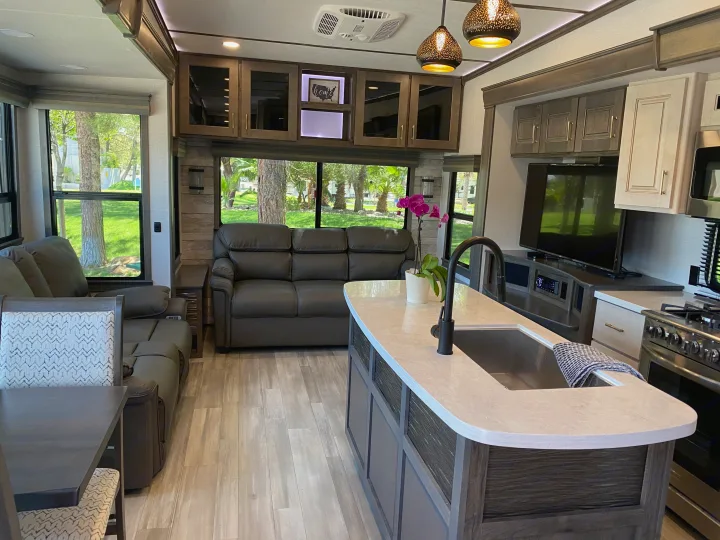 This luxurious RV rental offers a spacious, modern interior with a well-equipped kitchen, comfy living space, and large windows.. Alliance RV Paradigm 2021