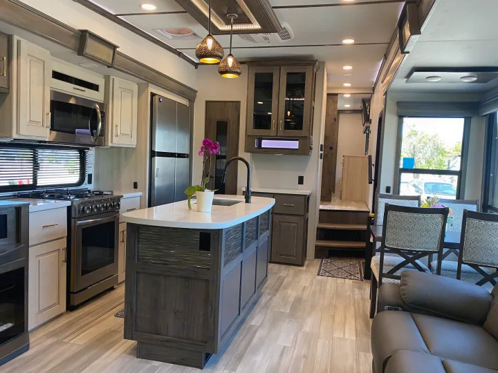 Explore this modern RV rental! Features a well-equipped kitchen with an island, dining area, and comfortable living space.. Alliance RV Paradigm 2021