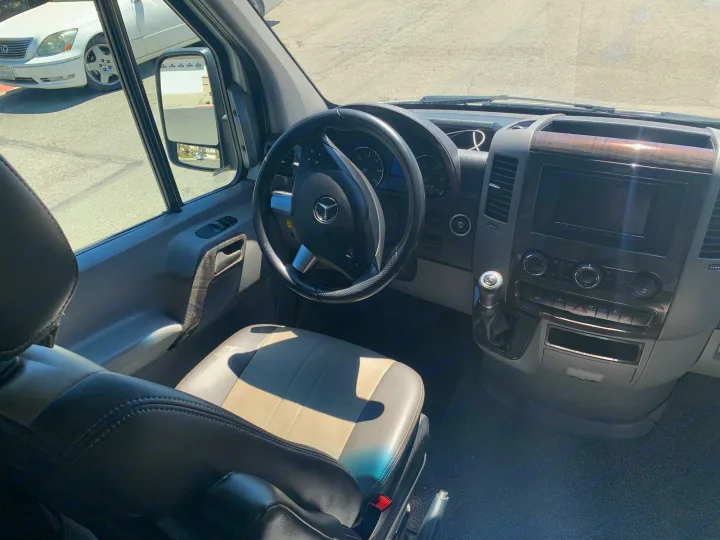 Driver's view inside an RV rental: Mercedes-Benz Sprinter dashboard, steering wheel, and front seats.. Roadtrek Agile Ss 2019