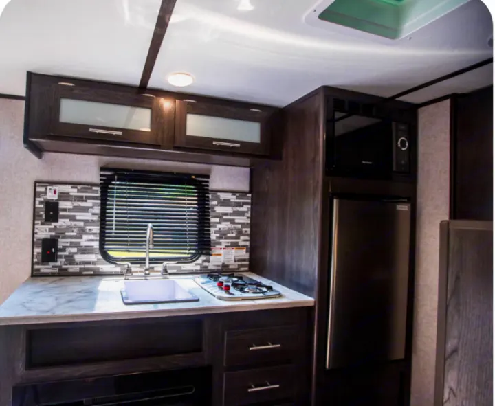 Compact RV rental kitchen: sink, stovetop, microwave, fridge, and cabinets for your travels.. Coleman COLEMAN LANTERN 2021