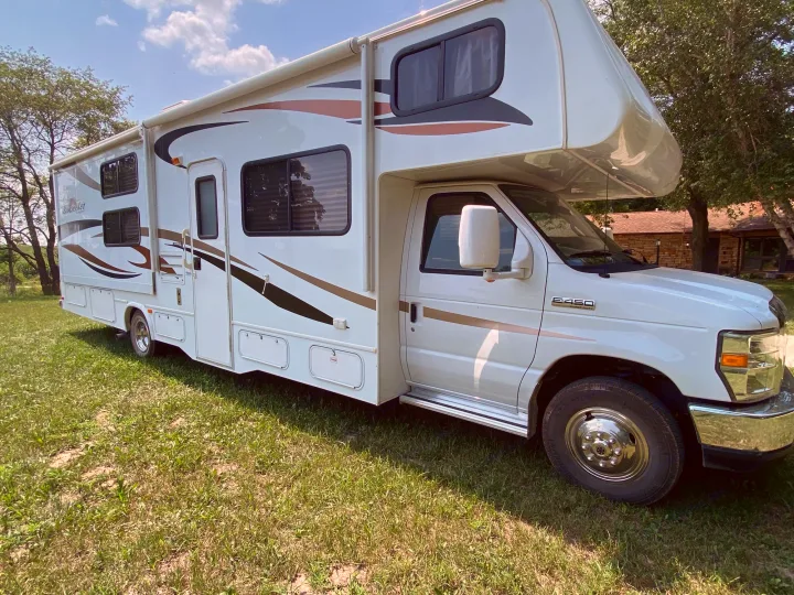 White Class C motorhome RV rental, Sunseeker E-450, parked on grass. Ready for your next adventure.. Forest River Ford Sunseeker 2013