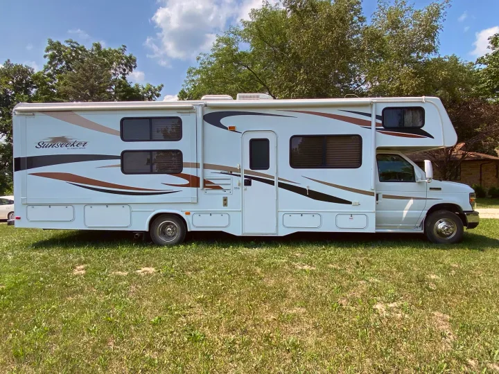 White Sunseeker Class C RV rental, parked on grass under a clear sky. A perfect motorhome for your next adventure.. Forest River Ford Sunseeker 2013