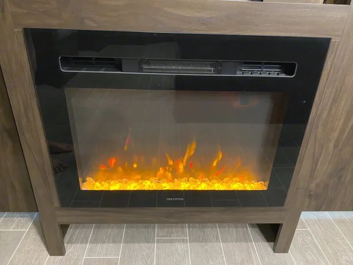 Cozy electric fireplace with artificial flames in an RV rental, perfect for chilly evenings.. Forest River Cherokee Alpha Wolf 2020