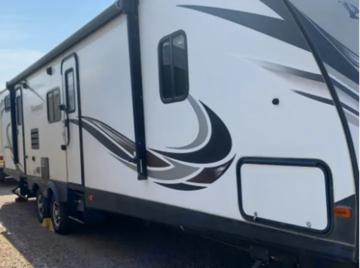 This white travel trailer RV rental, with black/gray graphics, doors, and windows, is ready for your next adventure.. Keystone Passport 2017