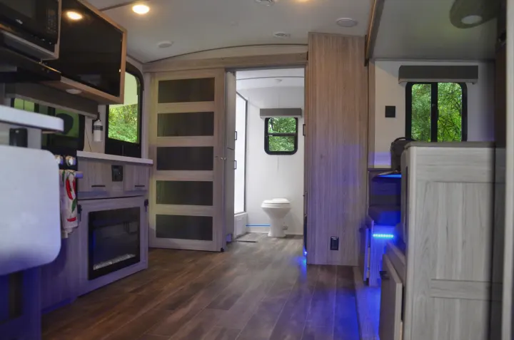 This RV rental interior offers a modern kitchen, living area with accent lighting, and a private bath, perfect for trips.. Keystone Passport 2021