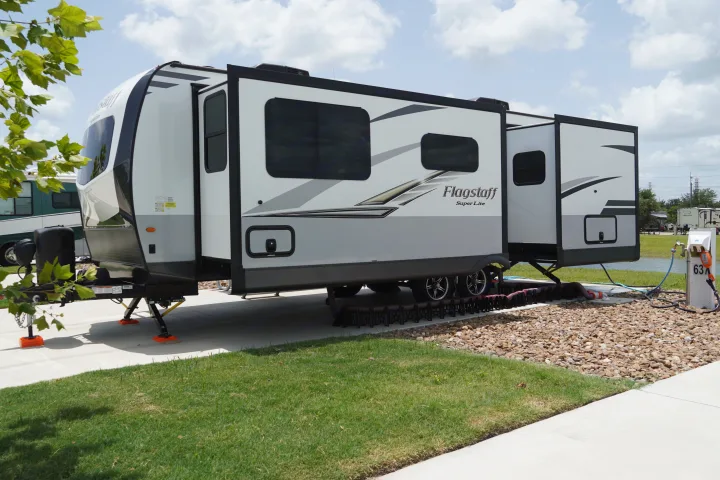Modern Flagstaff Super Lite RV rental fully set up with slide-outs and full hookups at a spacious site, ready for camping.. Forest River Flagstaff Super Lite 2021