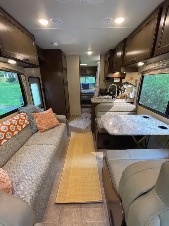 Cozy RV rental interior featuring a living area with sofa, dinette, kitchen, and view into the bedroom.. Thor Motor Coach Chateau 2017