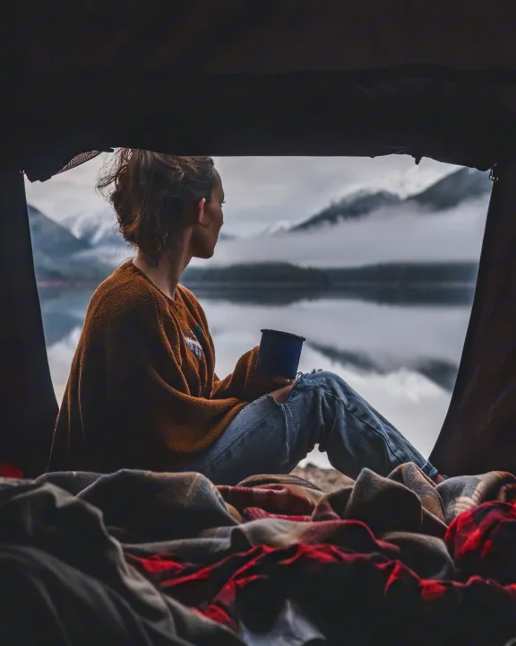 From a cozy rv rental, a person sips from a mug, admiring a serene, misty mountain lake view. Ideal for nature escapes.. Toyota 4Runner 2021