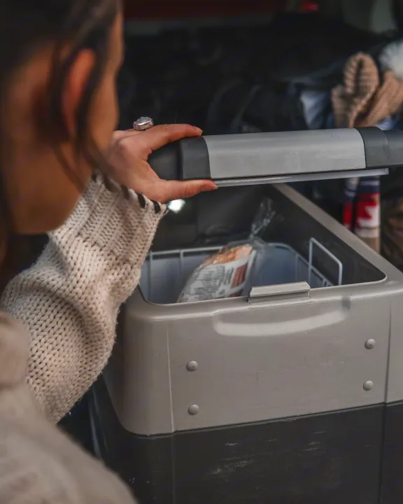 A traveler opens a portable fridge in their RV rental, revealing food for the trip.. Toyota 4Runner 2021