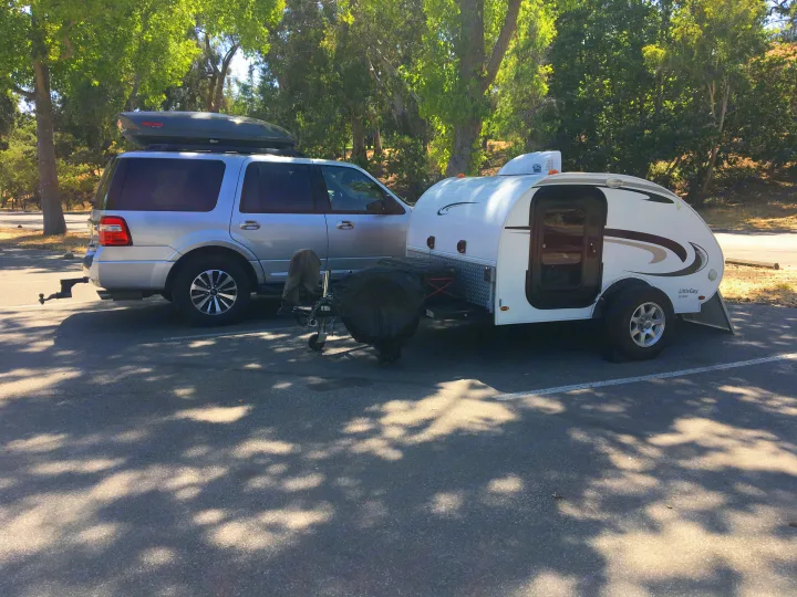 RV rental ready for adventure: Silver SUV with a roof box towing a white Little Guy teardrop camper.. Little Guy Other 2011