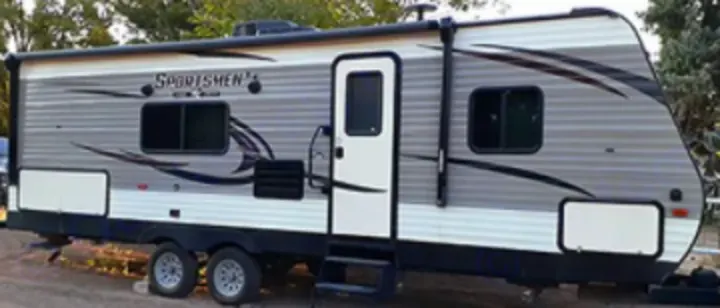 A well-maintained gray and white travel trailer, ready for your next RV rental journey.. KZSP Sportsman 260 2019