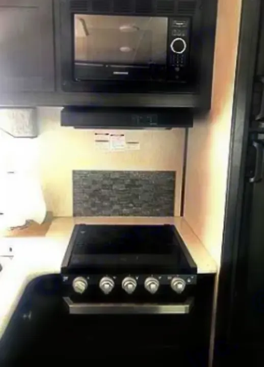This RV rental offers a compact kitchen: microwave, range, and tiled backsplash. Cook comfortably on your journey!. North Trail Ultralight 2019