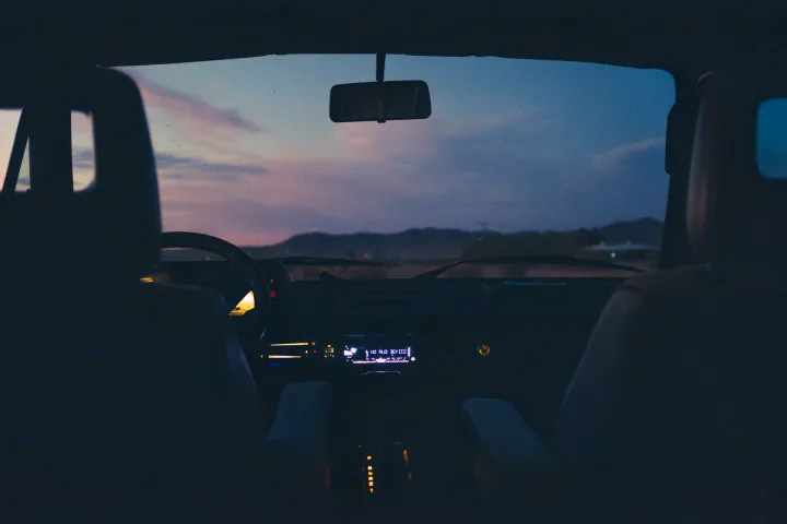 View from an RV rental at dusk: illuminated dashboard, gear shift, and serene sky with distant mountains.. Volkswagen Westfalia 1991