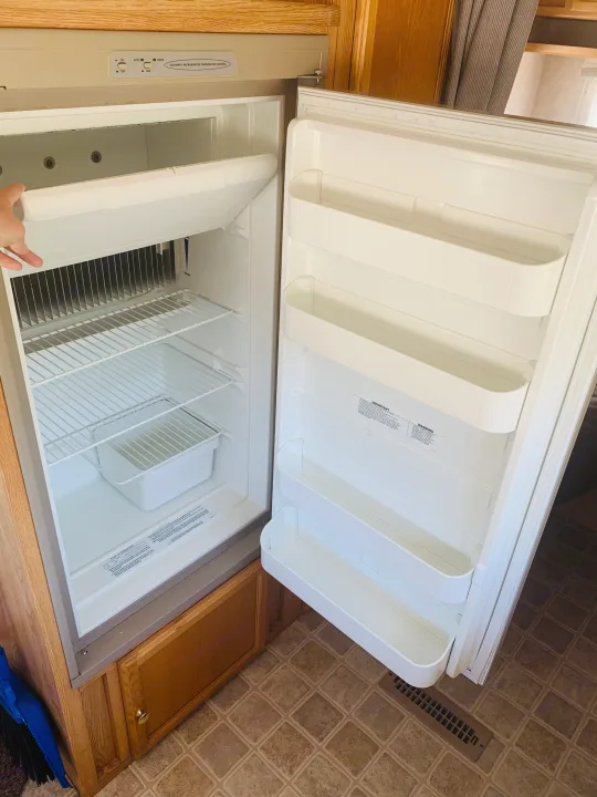 This RV rental features a clean, open refrigerator with wire shelves, door bins, and automatic temperature control.. Travel Lite Travel-Lite 800 2003
