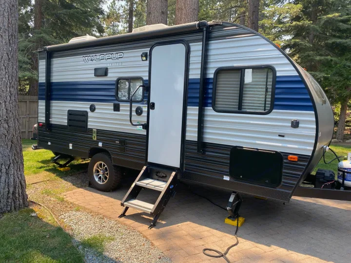 A Wolf Pup travel trailer, perfect for an rv rental, is parked on a paved site at a sunny campground.. Forest River Wolf Pup 2021