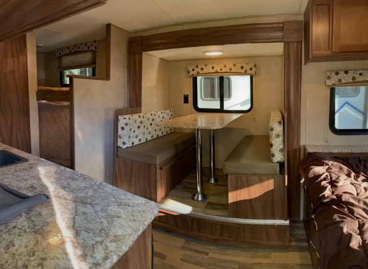 Inside a modern RV rental: dinette, bunk beds, kitchen, and private bedroom area. Perfect for travel trailer adventures.. Coachmen Clipper 2017