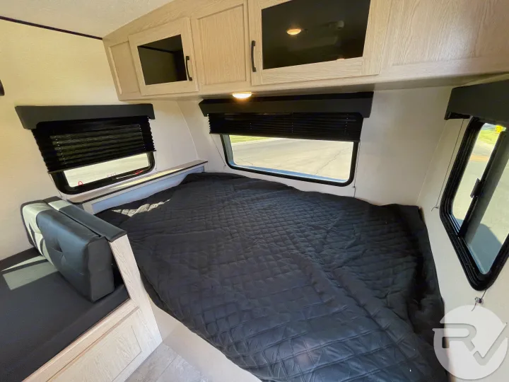 RV rental bedroom: comfy bed, light wood-look cabinetry, and dual windows with black privacy blinds.. Coachmen Apex 2021