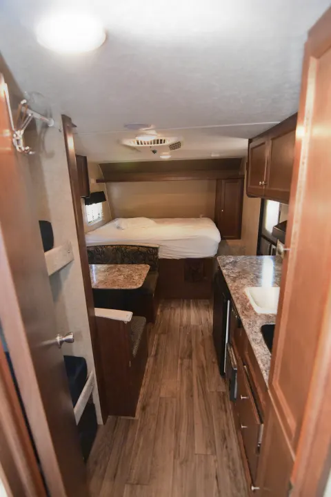 Spacious RV rental interior with a comfortable bed, dinette, and kitchenette, ready for your next adventure.. Keystone RV Hideout 2017