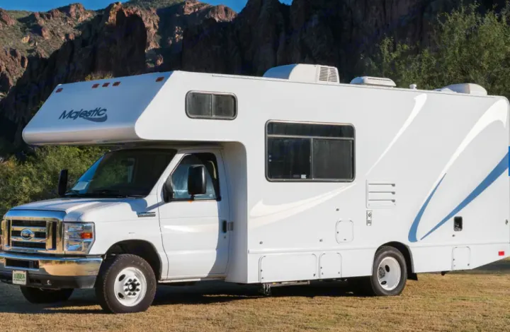 White Majestic Class C RV rental, parked outdoors with mountains in the background, ready for scenic travel and recreation.. Thor Motor Coach Four Winds Majestic 2013