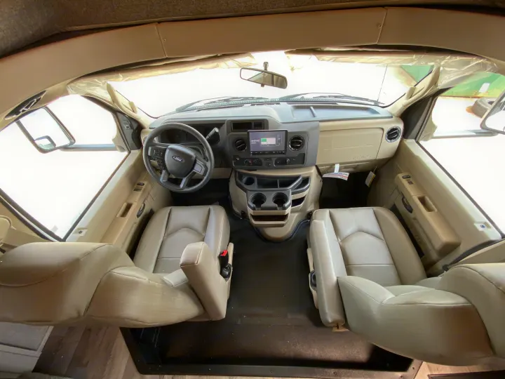 Inside an RV rental: the clean and spacious front cabin with Ford dashboard, two comfy seats, and Android Auto ready.. Jayco Redhawk 2025