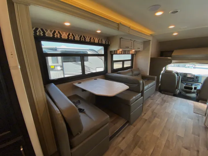 Spacious RV rental interior featuring a cozy dinette, lounge, and front cockpit. Perfect for travel adventures!. Jayco Redhawk 2025
