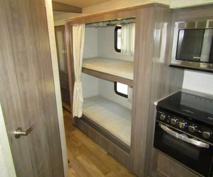 This RV rental offers bunk beds, a kitchen with a microwave and oven, and storage for comfortable travel.. Winnebago Vista 2022