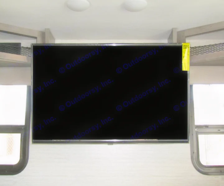 RV rental interior: large mounted TV with energy guide label, overhead lights, and windows. Ready for your adventure.. Winnebago Vista 2022